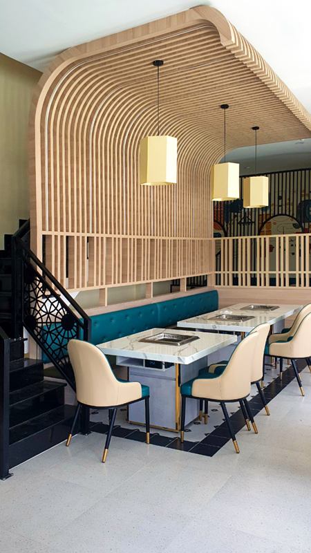 Khu bàn với vòm lam gỗ uốn cong và đèn thả